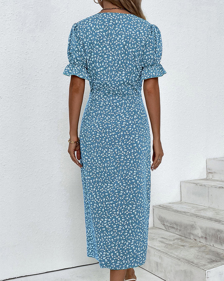 Blue v-neck midi dress with white floral print, short puff sleeves, button details at back