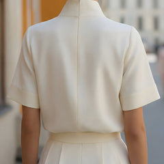 White structured blouse with stand collar and short sleeves, back view with center seam