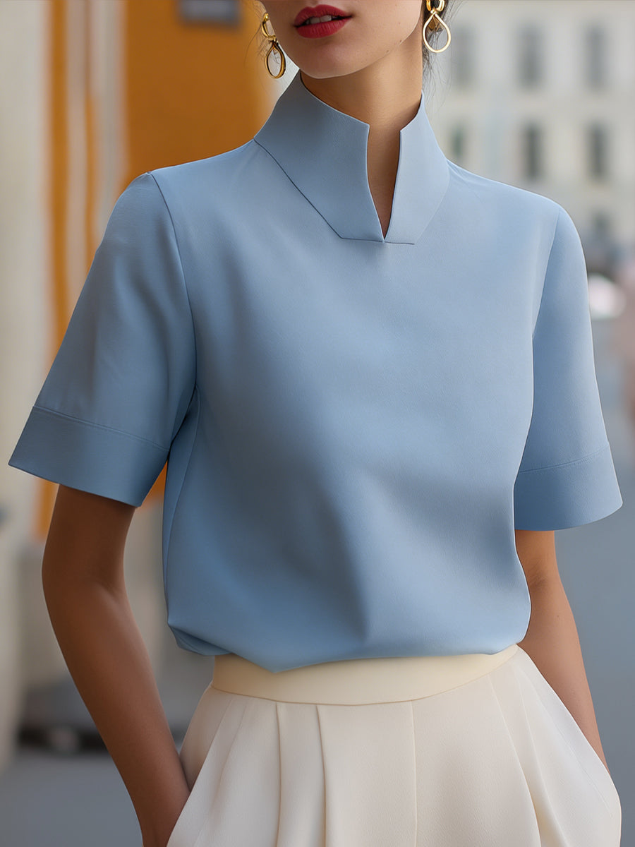 Light blue structured blouse with stand collar and short sleeves, clean minimalist front