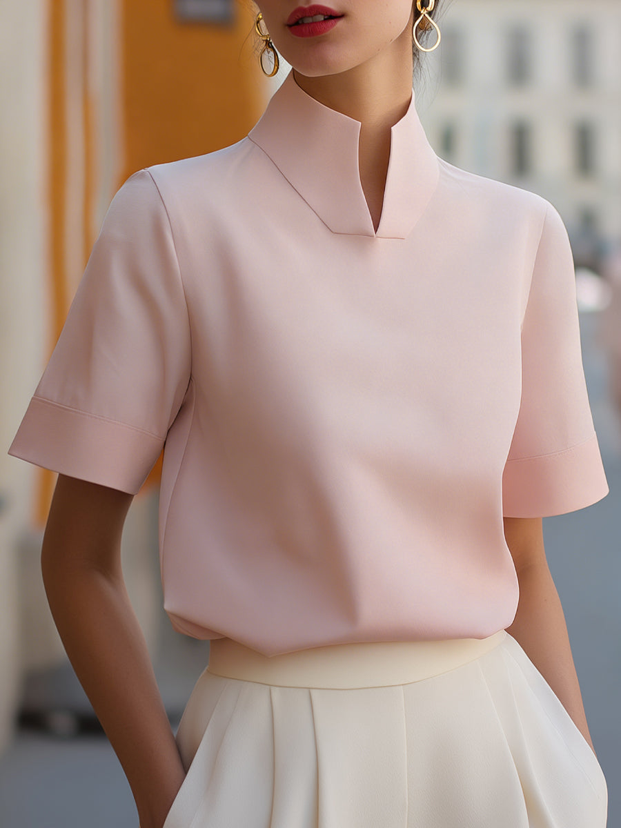 Blush pink structured blouse with stand collar and short sleeves, smooth minimalist front