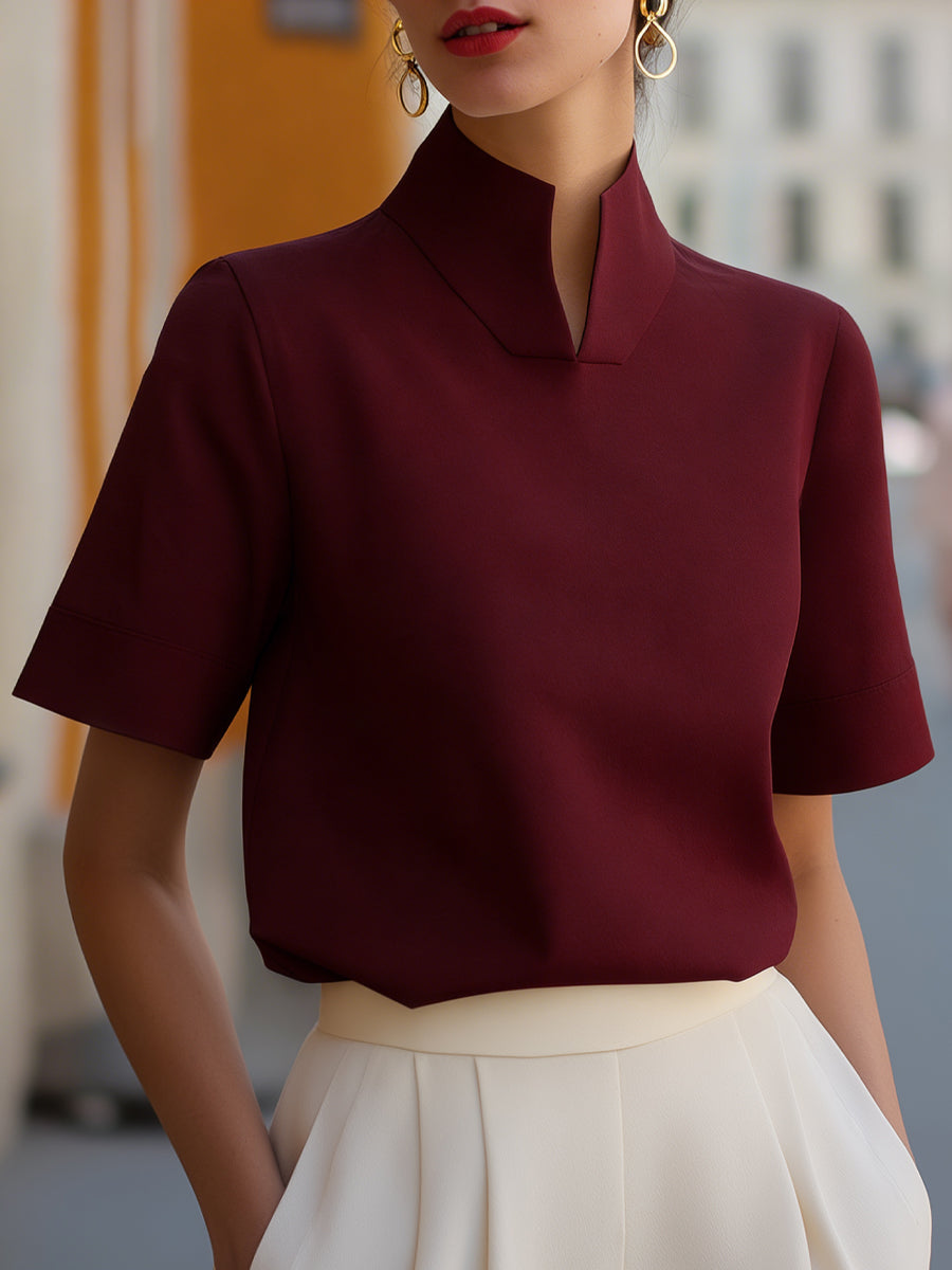 Burgundy structured blouse with stand collar and short sleeves, smooth minimalist front