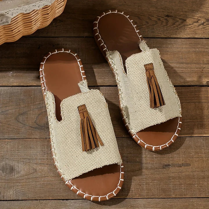 Casual orthopedic sandals with beige textured upper, brown tassel, and braided edges