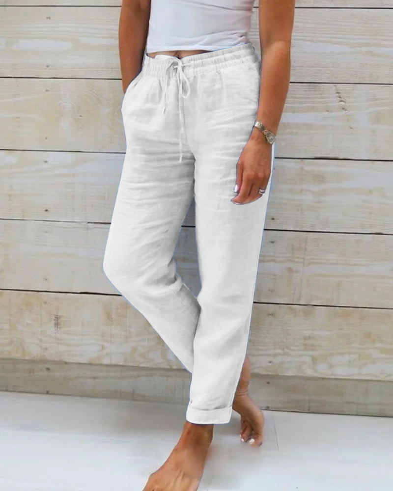 White cotton trousers with drawstring waist and tapered leg cuffs