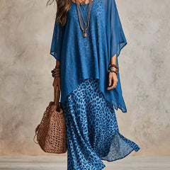 Blue bohemian maxi dress with blue leopard print skirt, sheer cape sleeves, tiered hem