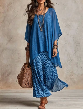 Blue bohemian maxi dress with blue leopard print skirt, sheer cape sleeves, tiered hem