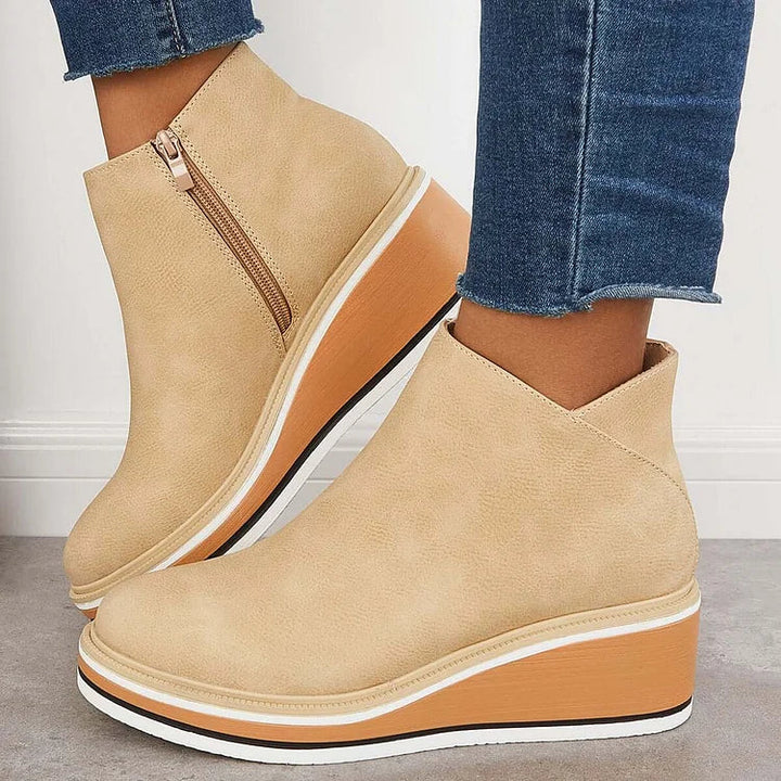 Beige suede-look ankle boots with side zipper and tan platform wedge, white sole