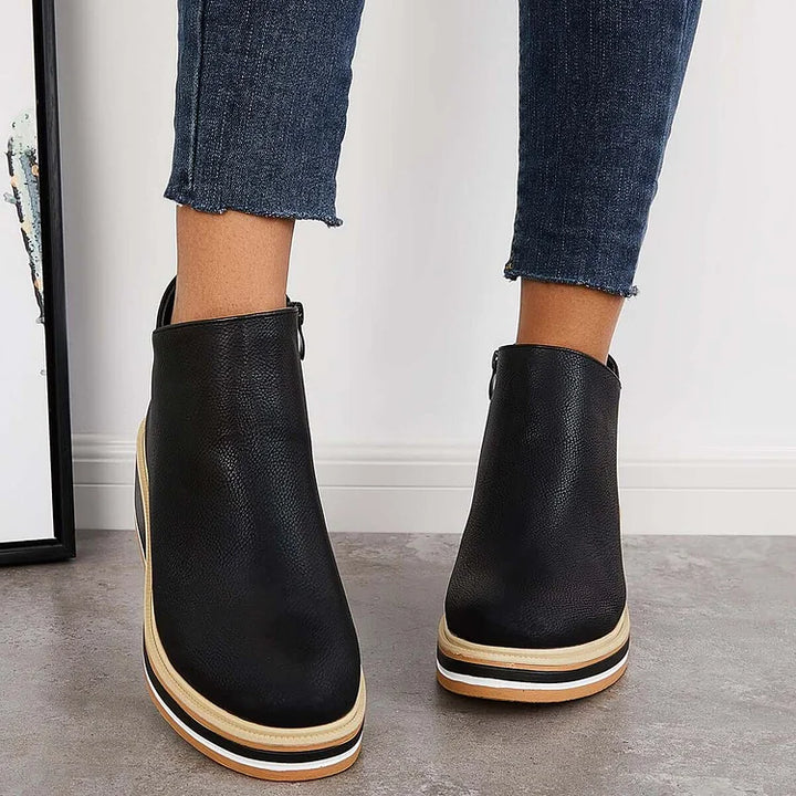 Black ankle boots with side zipper and tan-striped platform soles