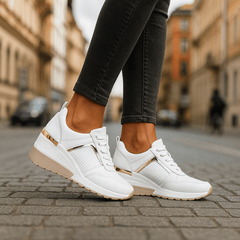 White lace-up sneakers with perforated panel and gold-tone heel stripe on white sole.