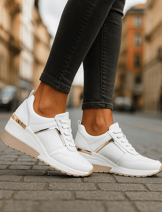White lace-up sneakers with perforated panel and gold-tone heel stripe on white sole.