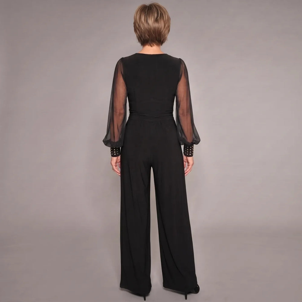 Black evening jumpsuit, back view: sheer sleeves, V-back, ruched waist, wide legs.