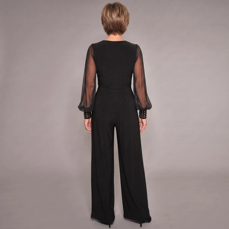 Black evening jumpsuit, back view: sheer sleeves, V-back, ruched waist, wide legs.
