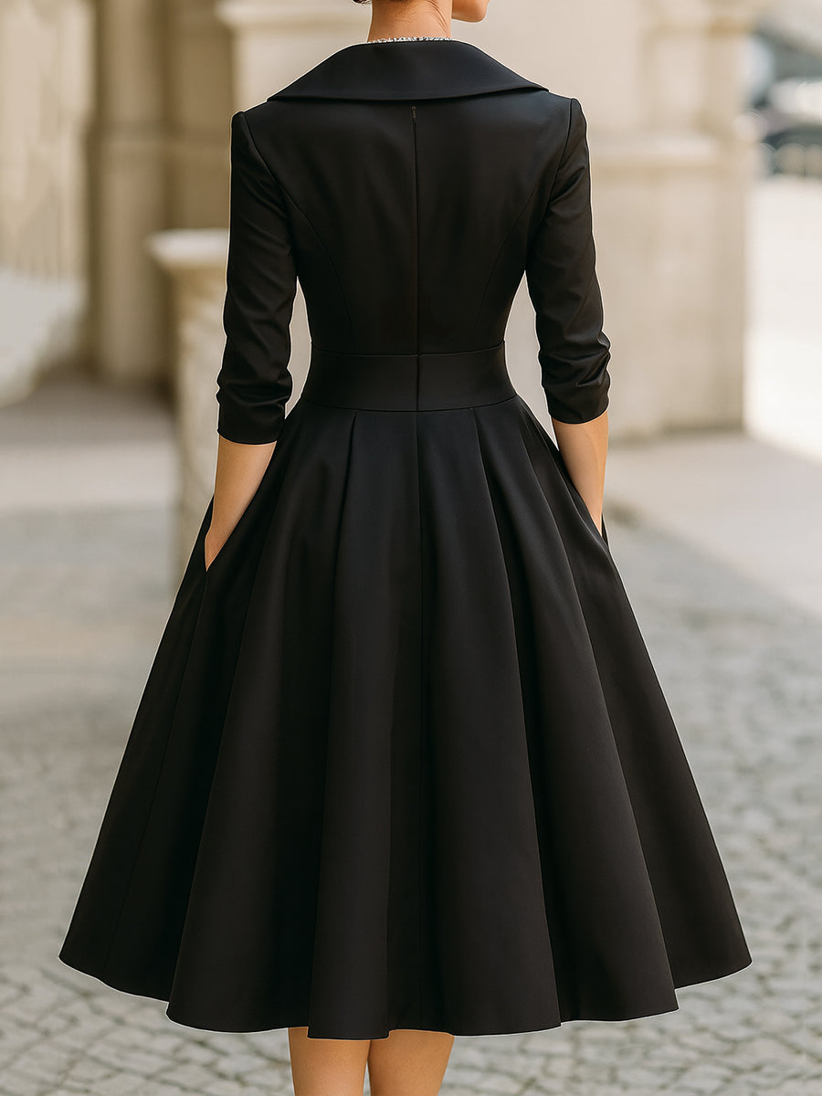 Black midi dress with V-back, button-free back yoke, and full pleated skirt