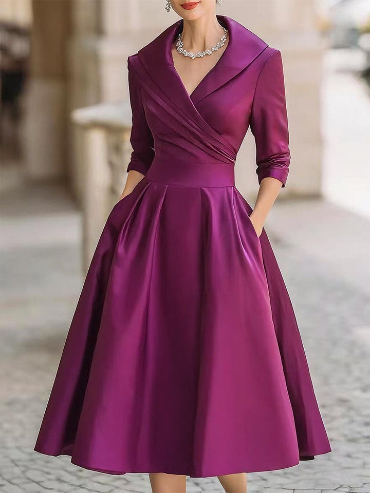 Purple wrap V-neck dress with 3/4 sleeves and flared knee-length skirt