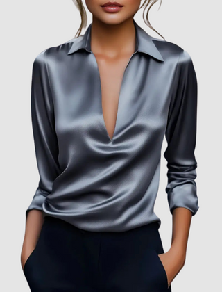 Blue satin blouse with pointed collar, deep V-neck, long sleeves, button cuffs.
