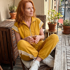 Mustard yellow zip-front jumpsuit with white striped sleeves and side stripe panels