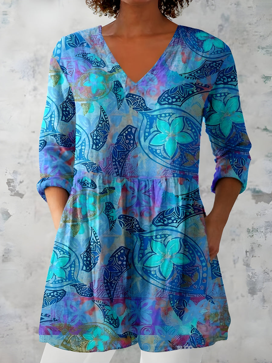 Blue long-sleeve V-neck blouse with colorful abstract print and peplum hem