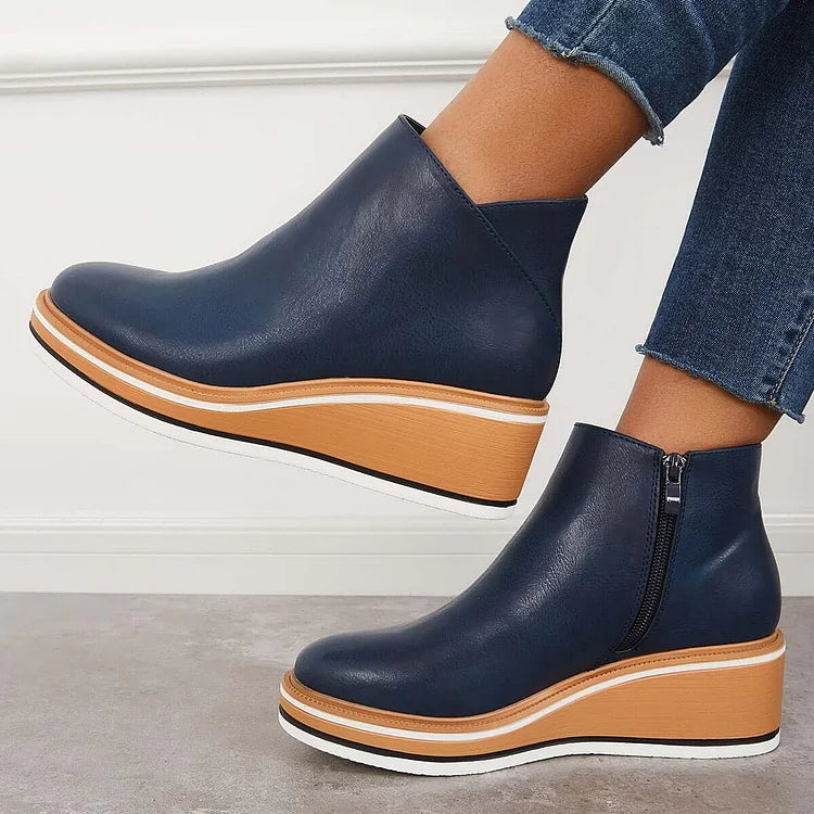 Blue ankle boots with side zipper and tan platform wedge, white sole edge