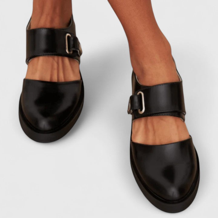 Black leather Mary Jane flats with double straps and metal buckle on top