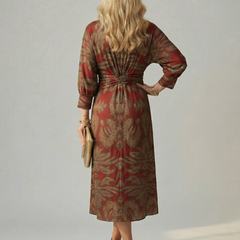 Back view of wrap midi dress with long sleeves in red and gold leafy print