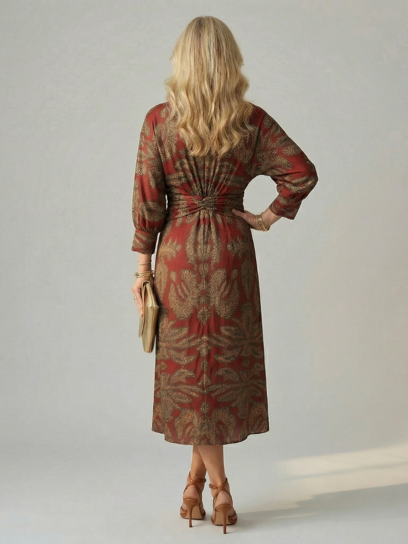 Back view of wrap midi dress with long sleeves in red and gold leafy print