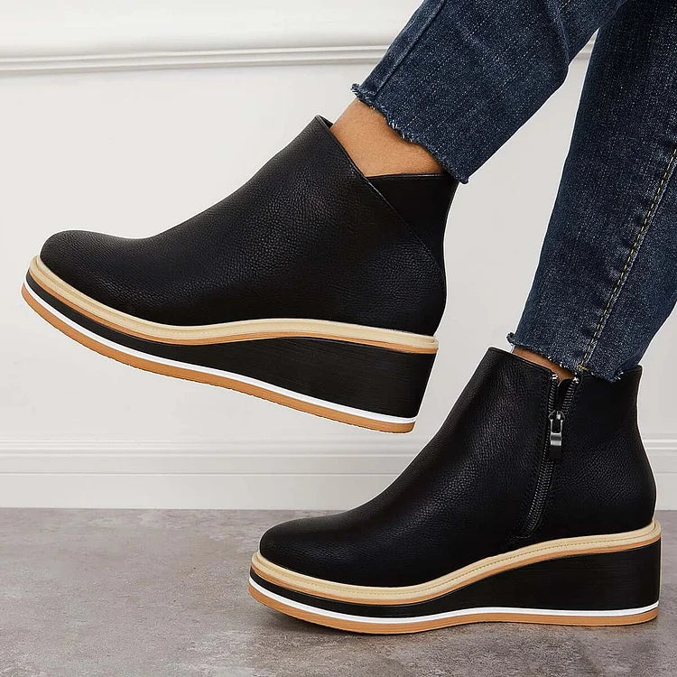 Black leather-look ankle boots with side zipper and tan-trimmed soles