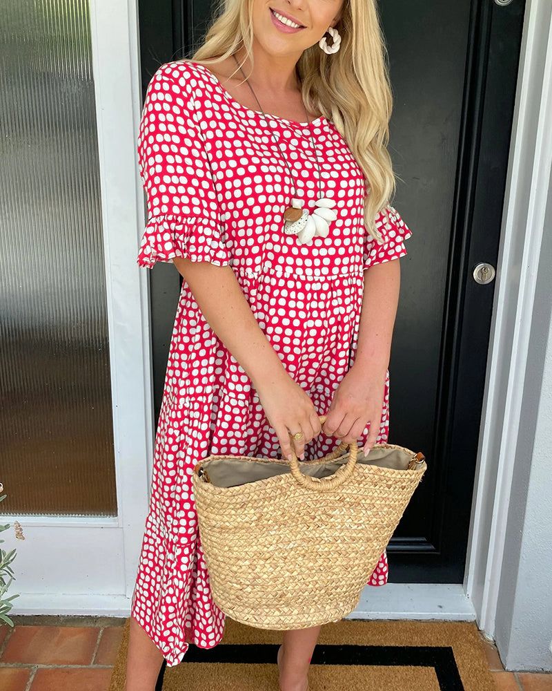 Red patterned summer dress with short sleeves and white daisy applique at chest