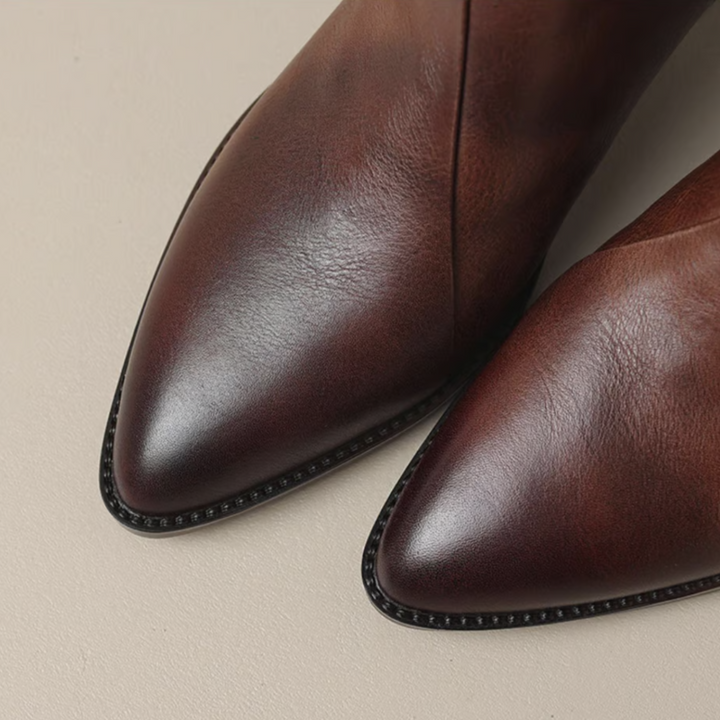 Brown leather ankle boots close-up of pointed toe and stitched welt edge