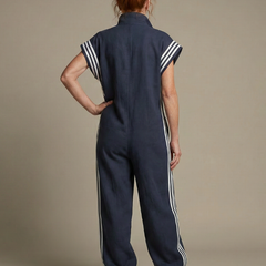 Back view of navy blue zip jumpsuit with white stripe accents on shoulders and legs