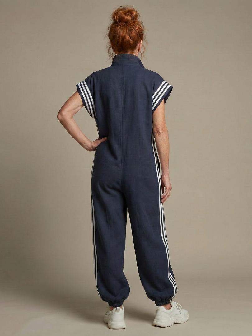 Back view of navy blue zip jumpsuit with white stripe accents on shoulders and legs
