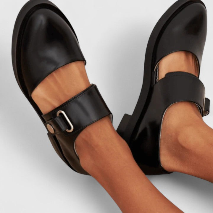 Black leather Mary Jane shoes, side view, with wide strap and buckle across instep