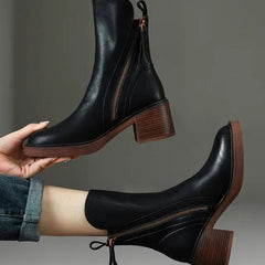 Black leather ankle boots with side zipper, tassel pull, and stacked block heel.