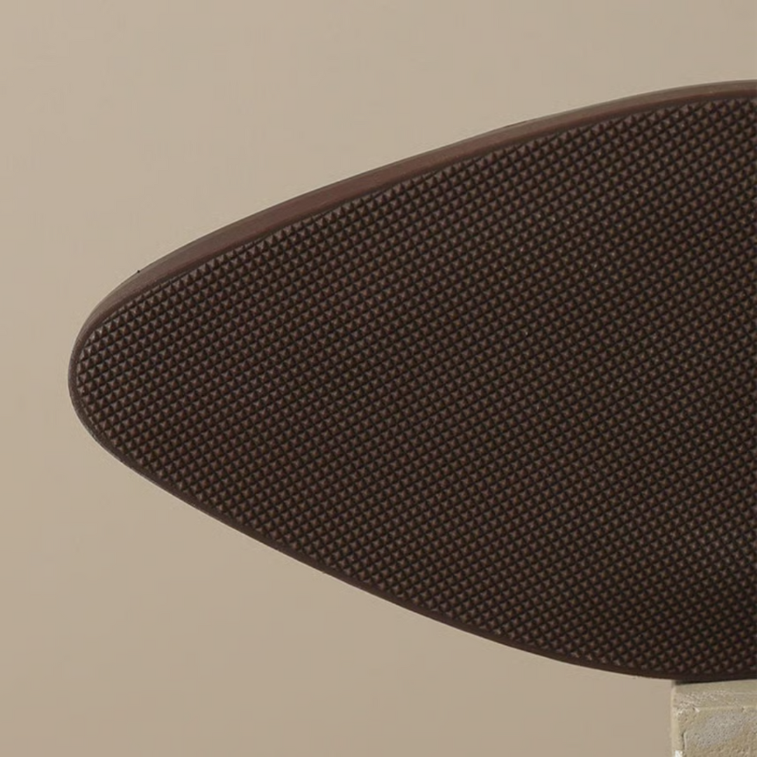 Brown outsole for ankle boots with textured tread pattern and grippy edge