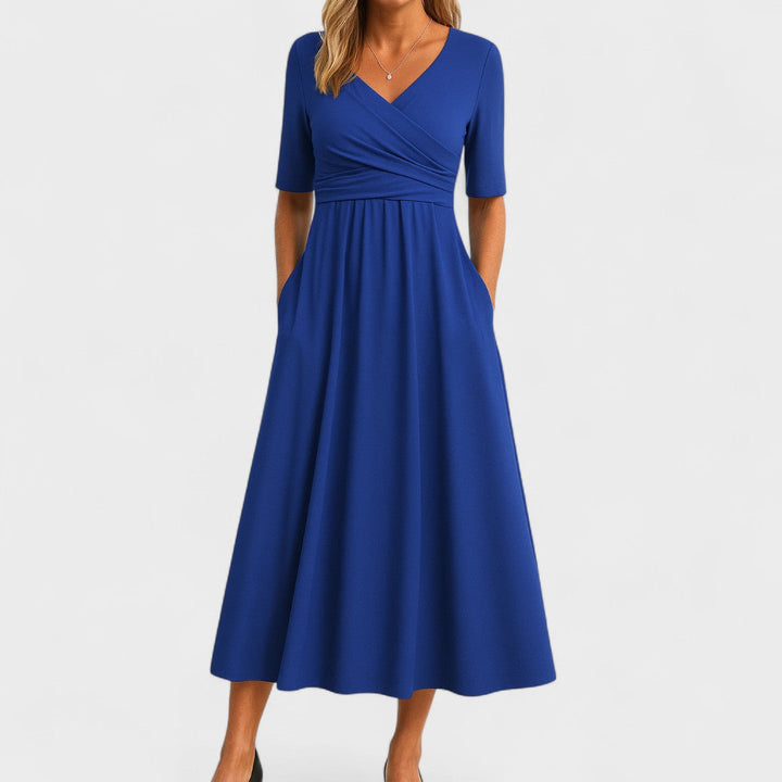Blue wrap-style midi dress with V-neck, short sleeves, and flowing gathered skirt