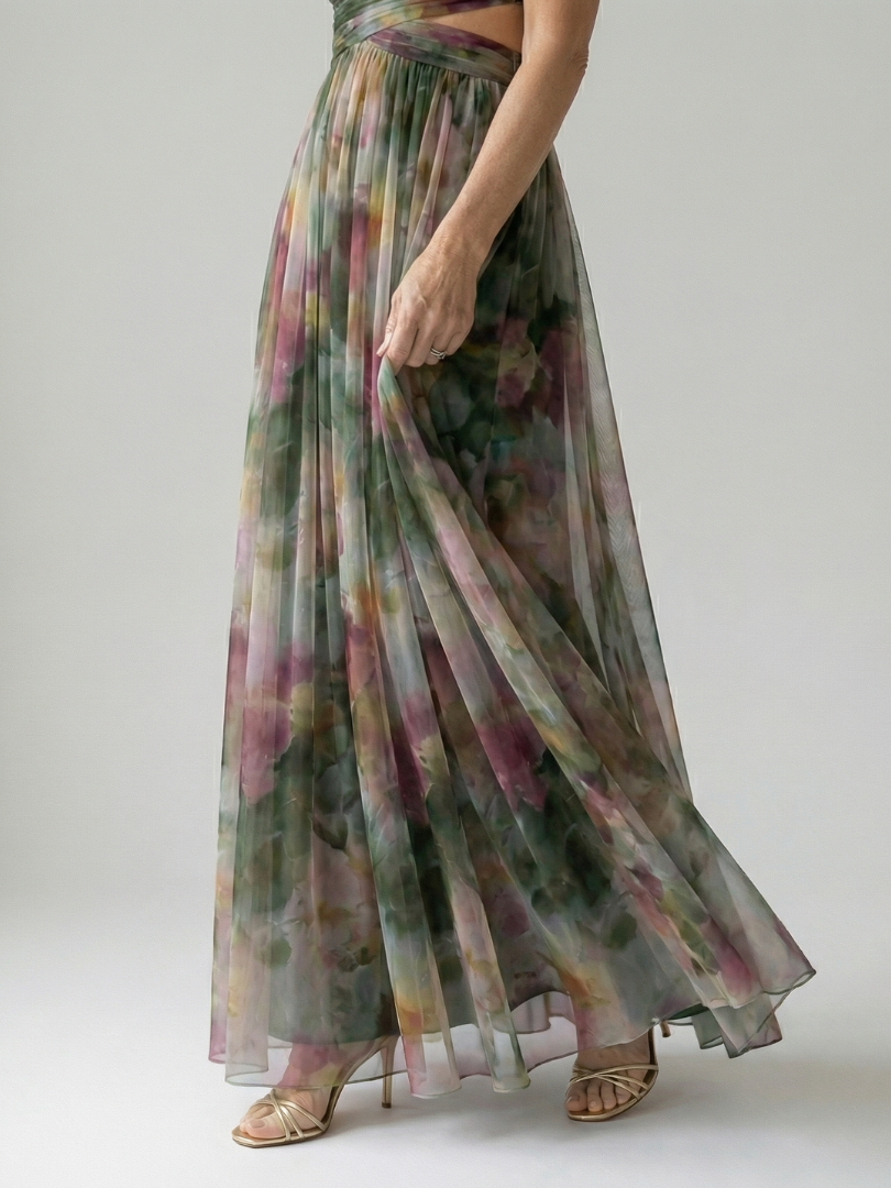 Multicolor maxi dress on model, V-neck with wrap bodice and flowing pleated skirt, side view.