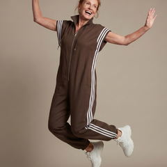 Brown zip stripe jumpsuit with short sleeves, white side stripes, and drawstring hood
