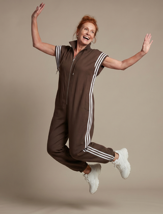 Brown zip stripe jumpsuit with short sleeves, white side stripes, and drawstring hood