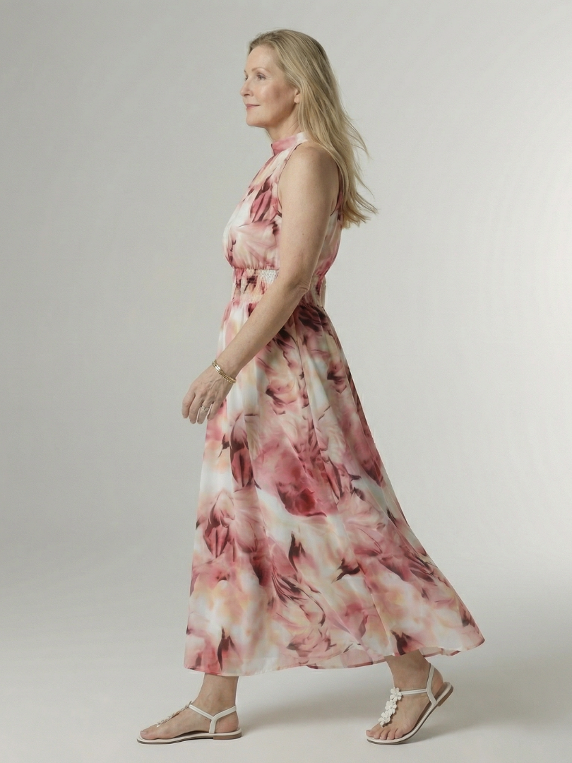Pink floral gathered halter midi dress, side view with sleeveless halter neckline.