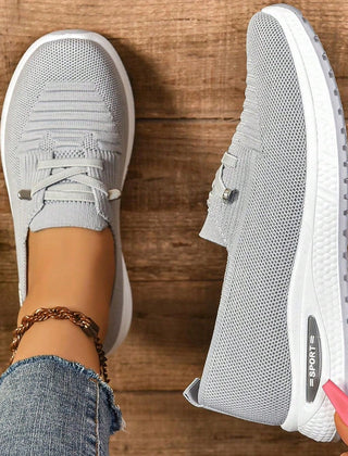 Gray lace-up sneakers side view with white outsole and branding on midsole