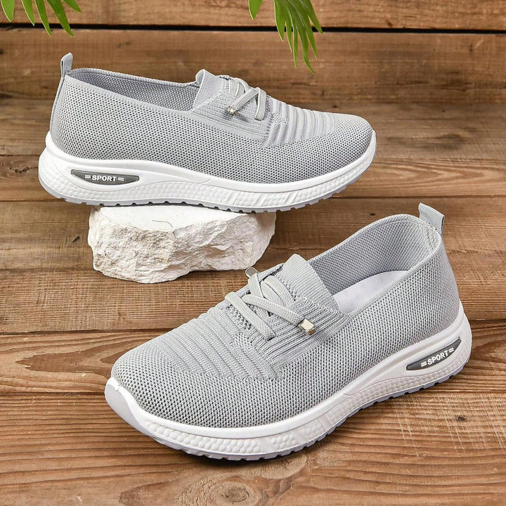 Gray lace-up knit sneakers with white soles and heel-to-toe tread