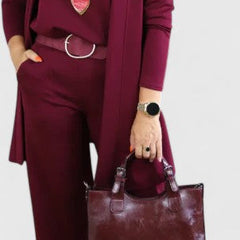 Burgundy three-piece outfit with long blazer, layered necklace, and wide-leg pants