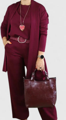 Burgundy three-piece outfit with long blazer, layered necklace, and wide-leg pants