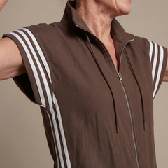 Brown zip jumpsuit close-up with stand collar, drawstring ties, and white striped sleeves
