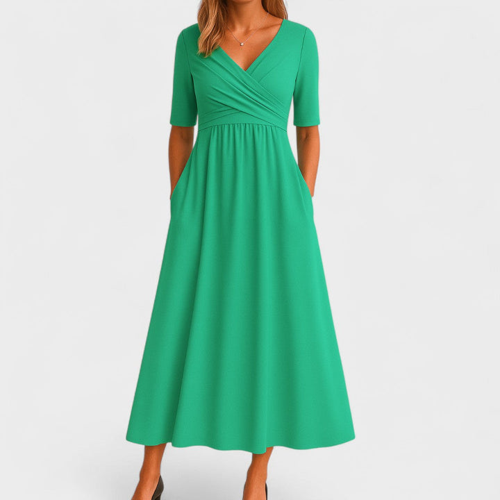 Green wrap-style midi dress with V-neck, short sleeves, and softly gathered skirt