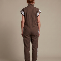 Back view of brown zip jumpsuit with white stripe accents at shoulders and legs