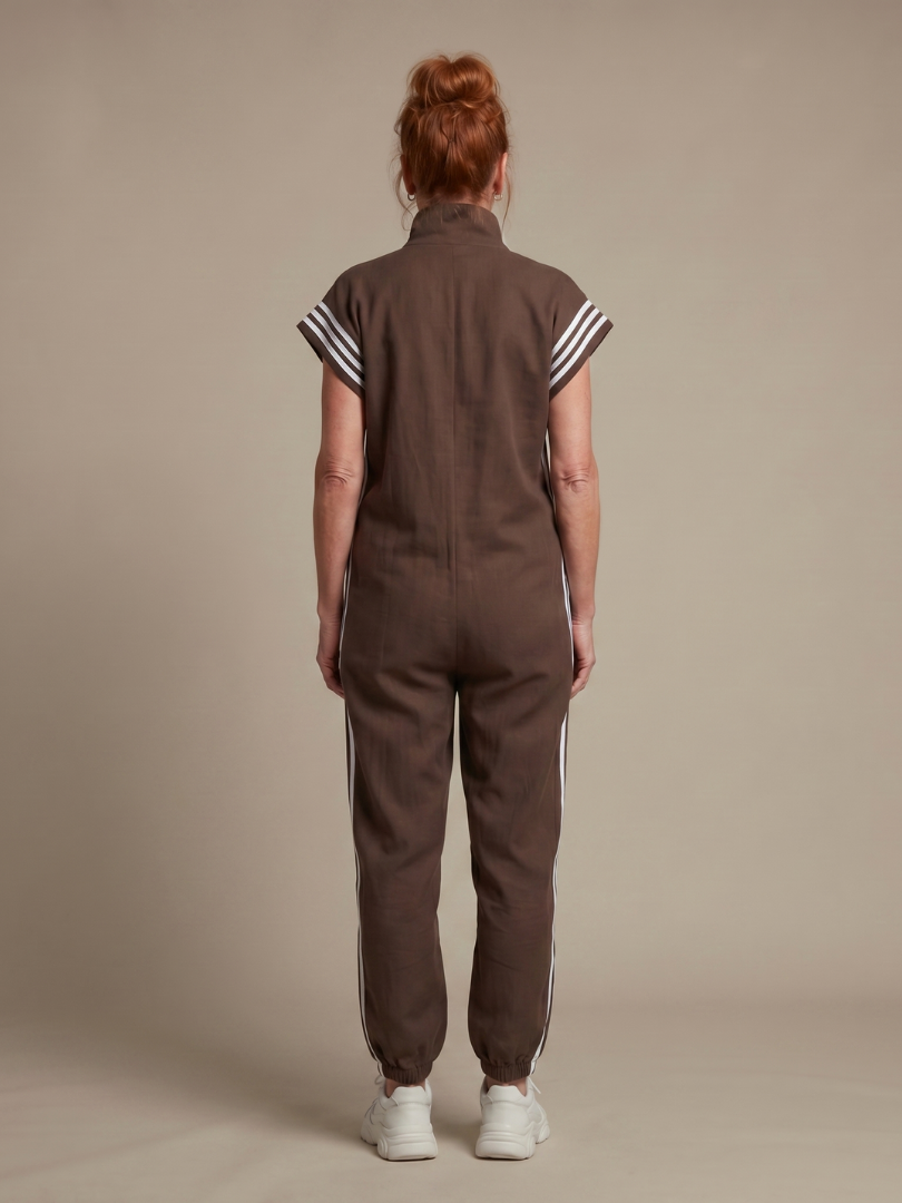 Back view of brown zip jumpsuit with white stripe accents at shoulders and legs