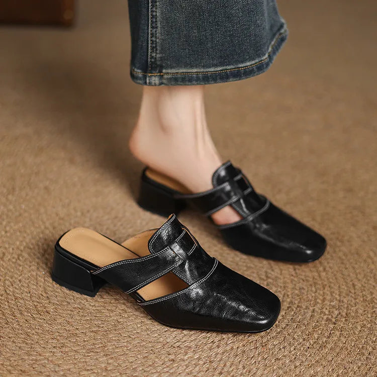 Black leather mule on foot with crossover strap and low block heel