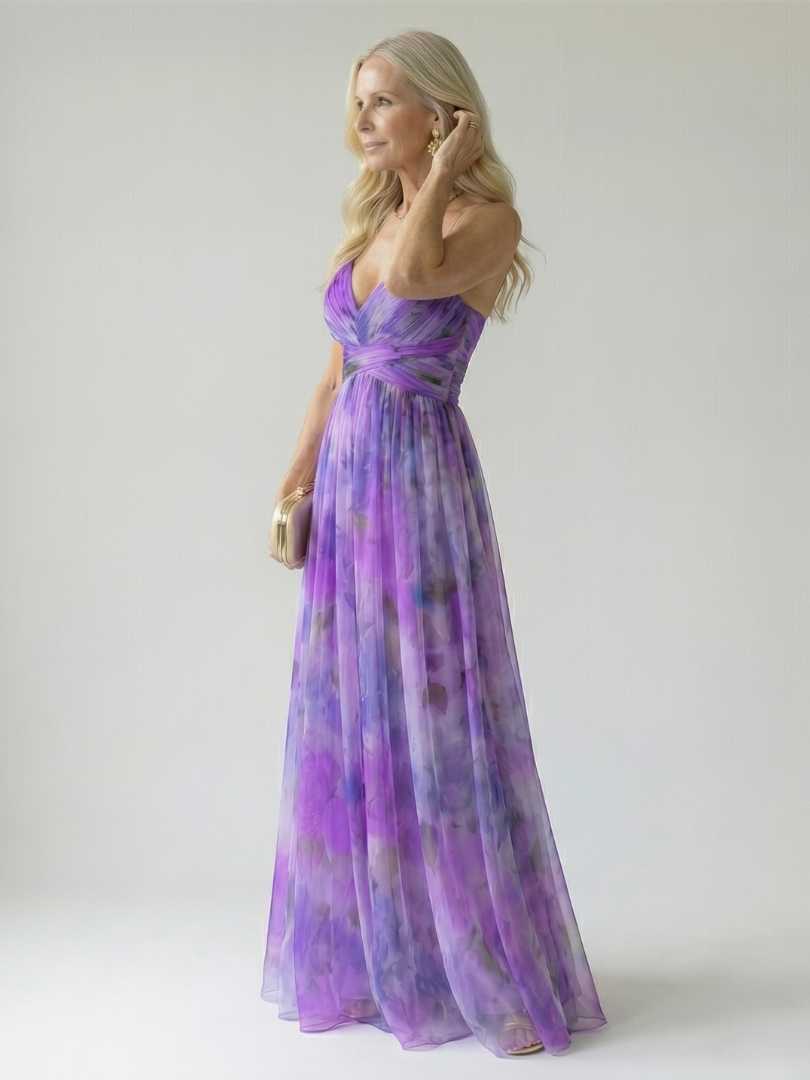 Purple maxi dress with V-neck wrap bodice and crisscross waist, sleeveless spaghetti straps, side view.