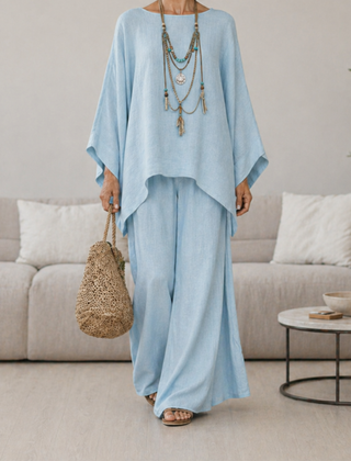 Light blue two-piece set with draped tunic top and wide-leg pants, long sleeves.