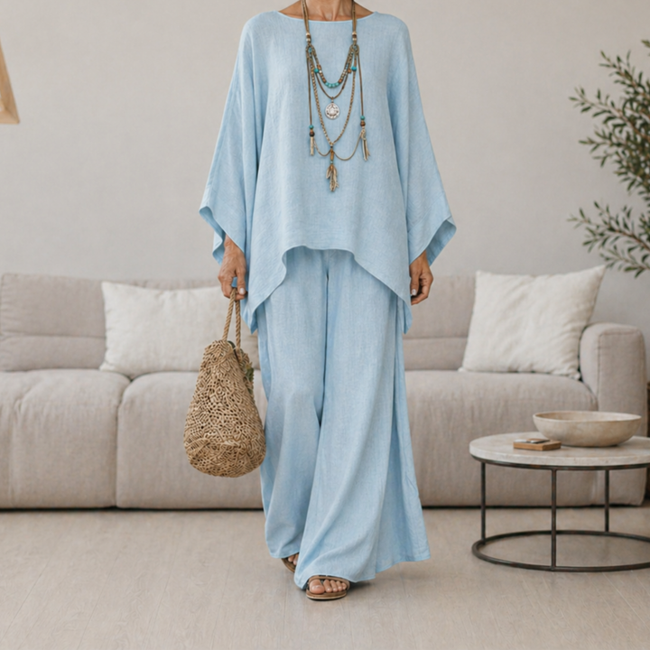 Light blue two-piece set with draped tunic top and wide-leg pants, long sleeves.