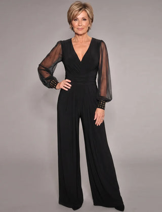 Black evening jumpsuit with V-neck, ruched waist, sheer long sleeves, and wide legs.